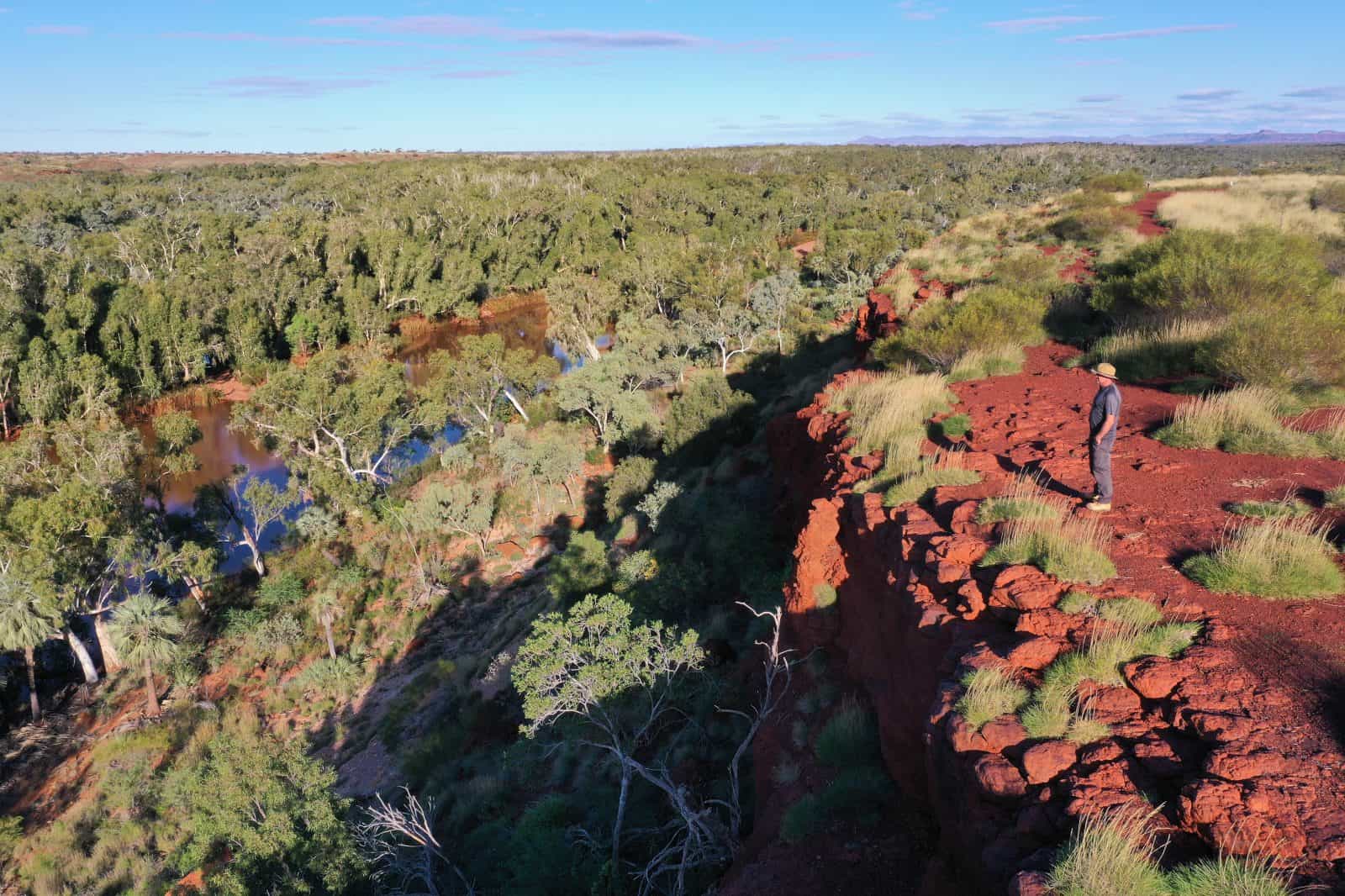 Aerial landscape view of Australian man standing on a cliff looking at Fortescue River in Millstream Chichester National Park in the Pilbara region Western Australia