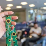 Hand holds a sunflower lanyard, representing invisible disabilities awareness as part of Neurodiverse Talent Internship
