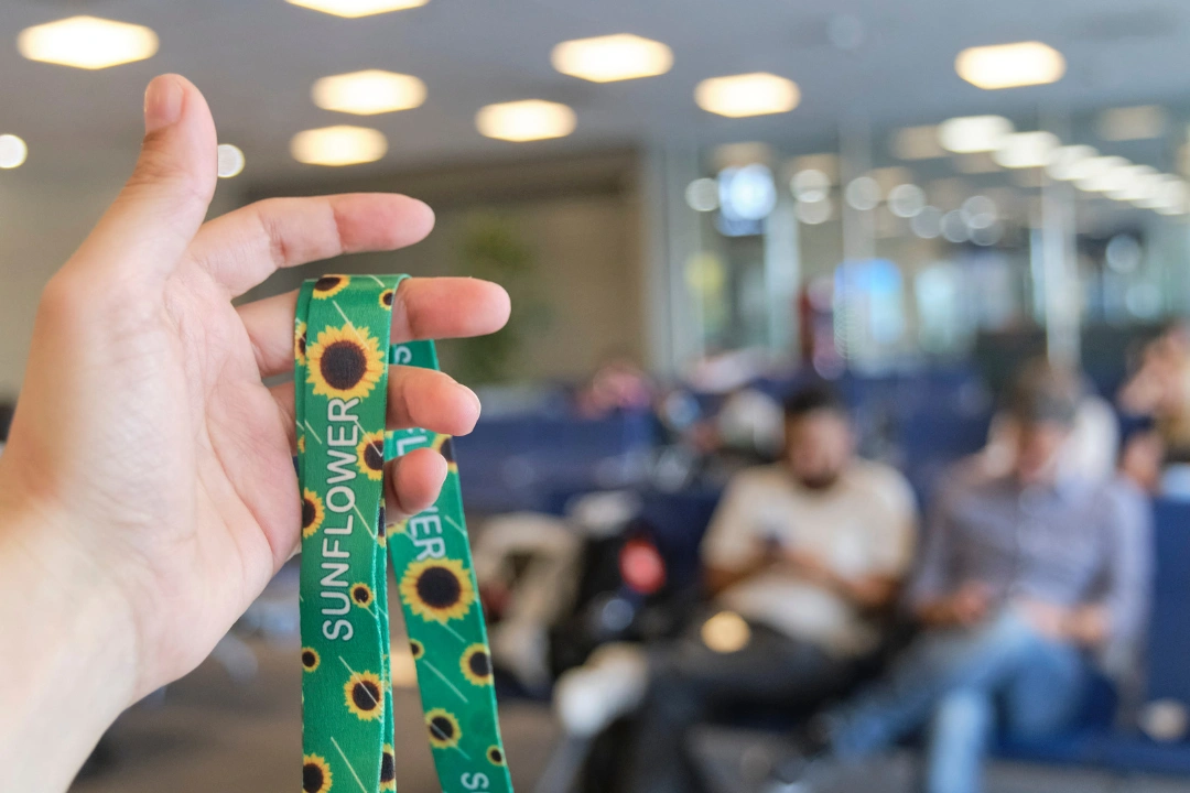 Hand holds a sunflower lanyard, representing invisible disabilities awareness as part of Neurodiverse Talent Internship